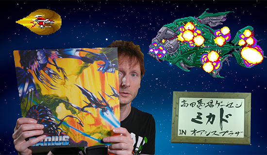 An image with a photo of me holding up the Darius 1 vinyl release, with a space background. Pictured around me are the sign for Mikado arcade in Tokyo's Takadanobaba, alongside sprites of the Silverhawk ship from Darius 1 confronting boss Fatty Glutton.